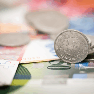 Swiss francs coins on colorful banknotes