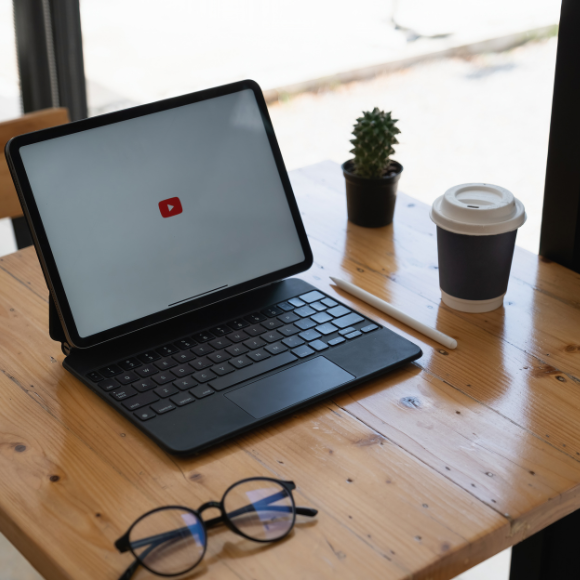 Tablet with keyboard on café table, coffee nearby.