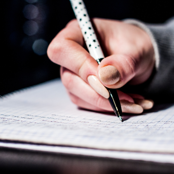 Handwriting notes on graph paper with pen