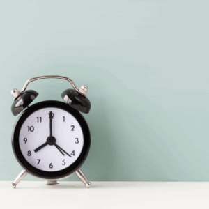 Black alarm clock on teal background