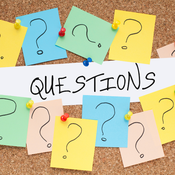 Colorful question marks and 'questions' text on corkboard.